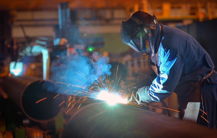 Man Working On Metal In Factory